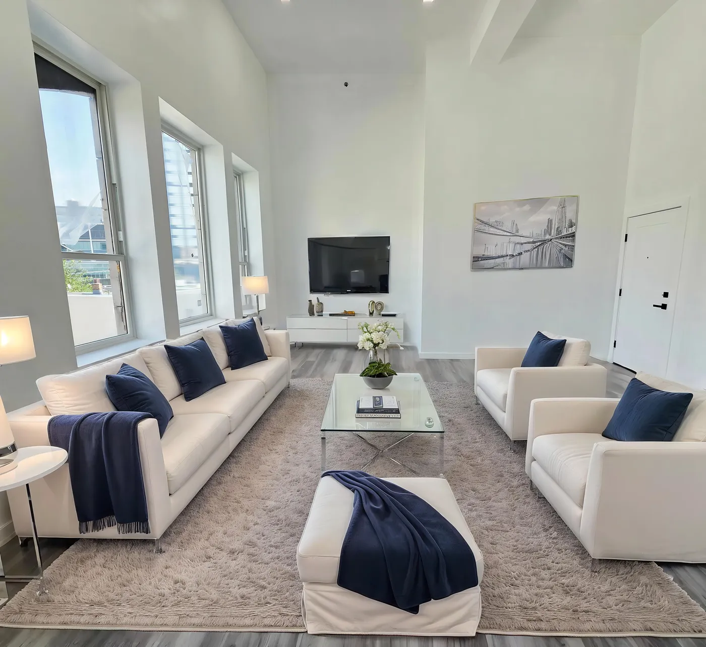 One-bedroom apartment interior with living area, white sofa, and floor-to-ceiling windows